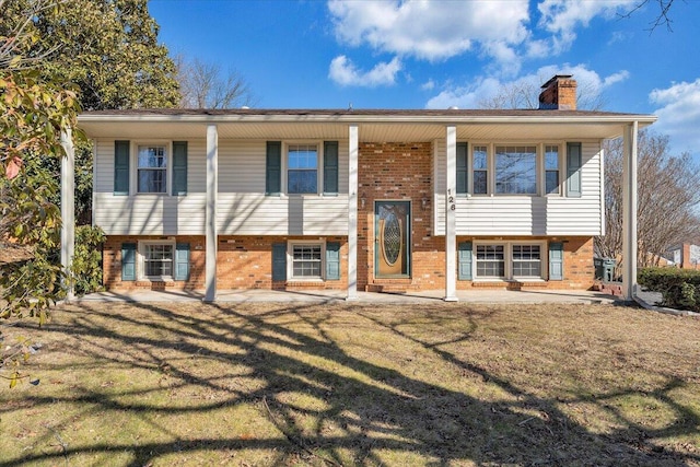 split foyer home with a patio area and a front yard