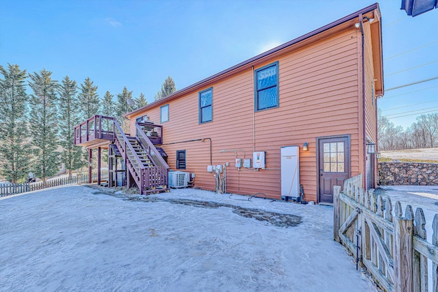 snow covered house featuring central air condition unit