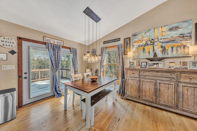 dining space with vaulted ceiling and light hardwood / wood-style floors