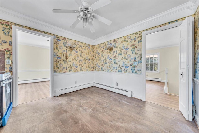 spare room featuring ceiling fan, a baseboard heating unit, and ornamental molding