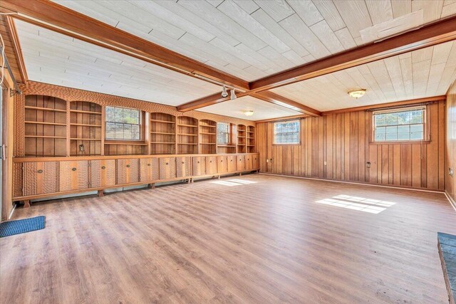 unfurnished living room with a fireplace, hardwood / wood-style floors, and beamed ceiling