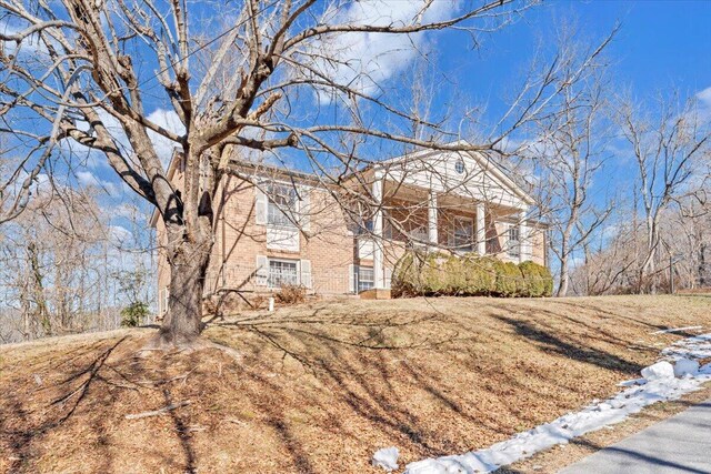 neoclassical home with a porch and a lawn