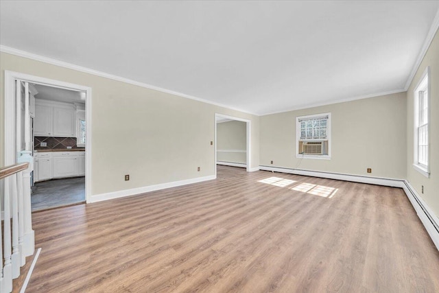 unfurnished living room featuring crown molding, light wood-type flooring, and a wealth of natural light