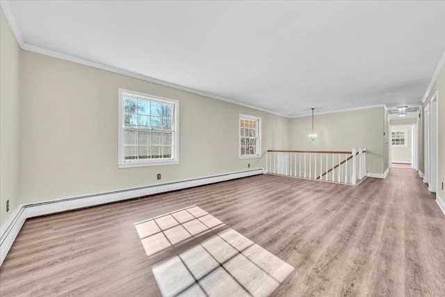 spare room featuring crown molding, light hardwood / wood-style flooring, a notable chandelier, and a baseboard heating unit