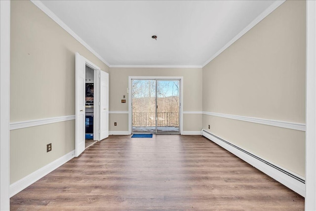 spare room featuring ornamental molding, a baseboard heating unit, and hardwood / wood-style floors