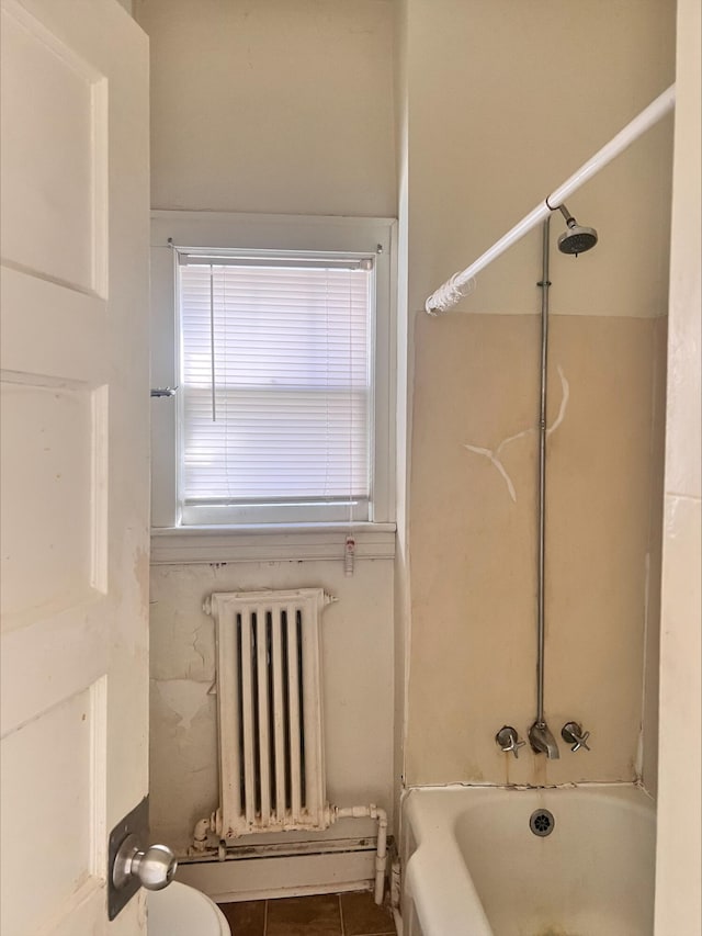 bathroom with  shower combination, radiator, and tile patterned floors