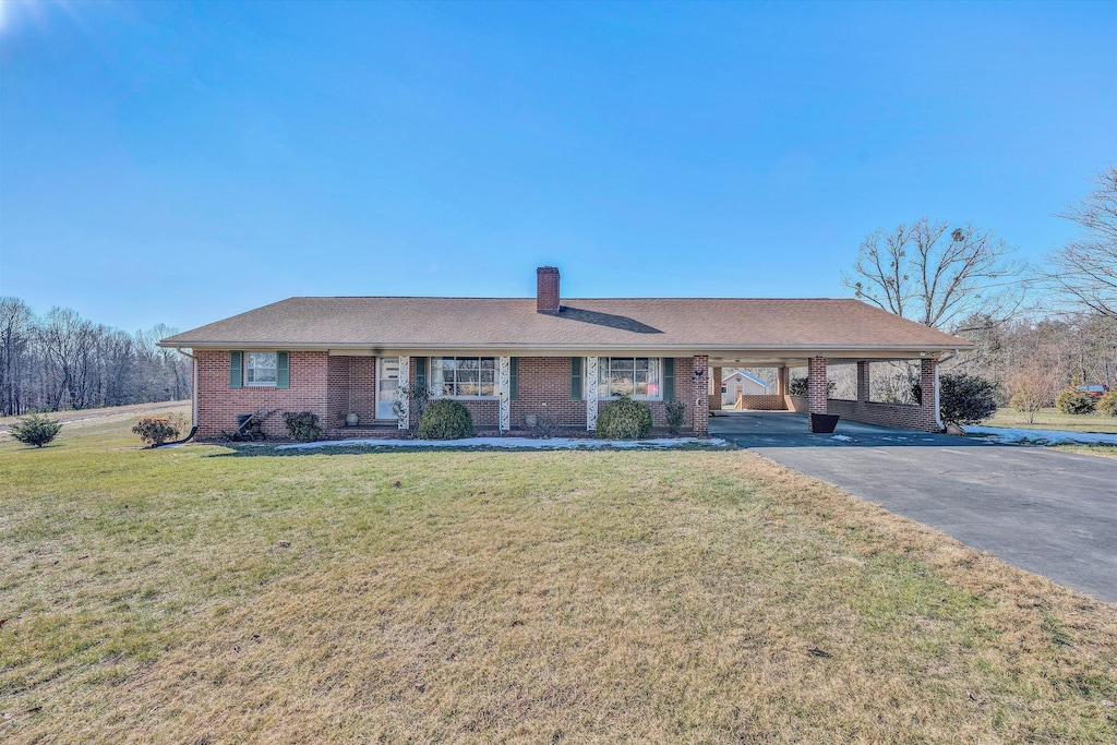 ranch-style house featuring a front lawn and a carport