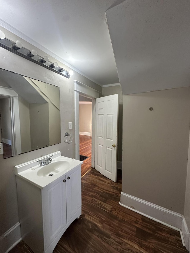 bathroom with hardwood / wood-style flooring, crown molding, and vanity