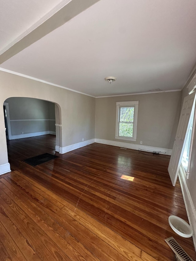 unfurnished room with ornamental molding and dark wood-type flooring