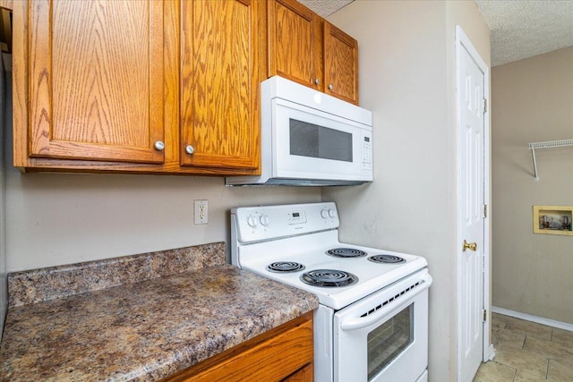 kitchen featuring white appliances and a textured ceiling