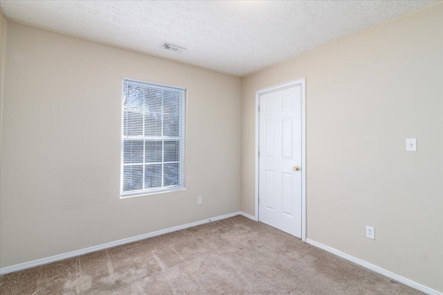 unfurnished bedroom featuring a textured ceiling and light colored carpet