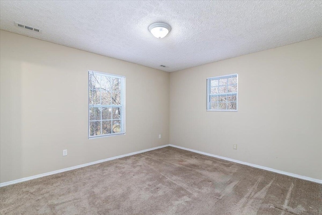 unfurnished room featuring carpet flooring and a textured ceiling