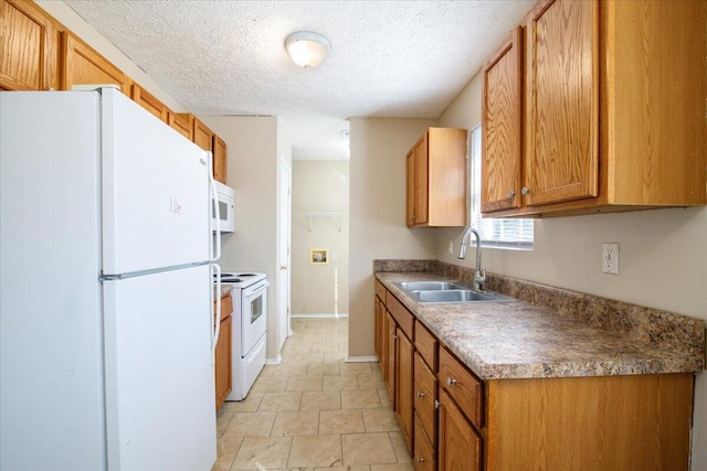 kitchen with white appliances, a textured ceiling, and sink