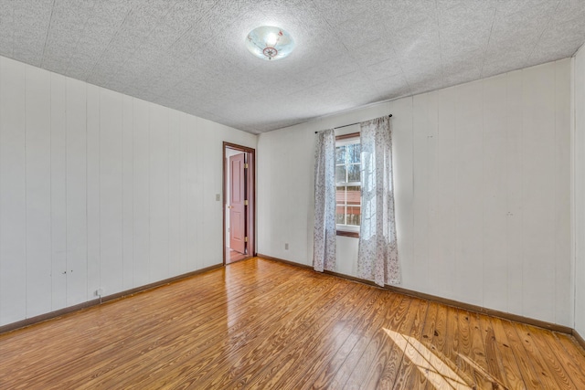 unfurnished room with hardwood / wood-style flooring