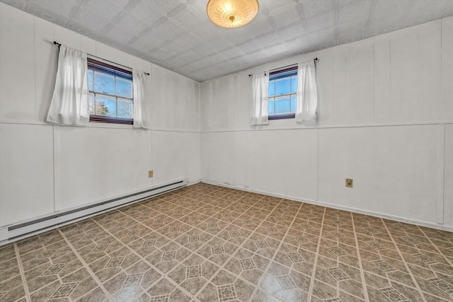 unfurnished room featuring a healthy amount of sunlight and baseboard heating