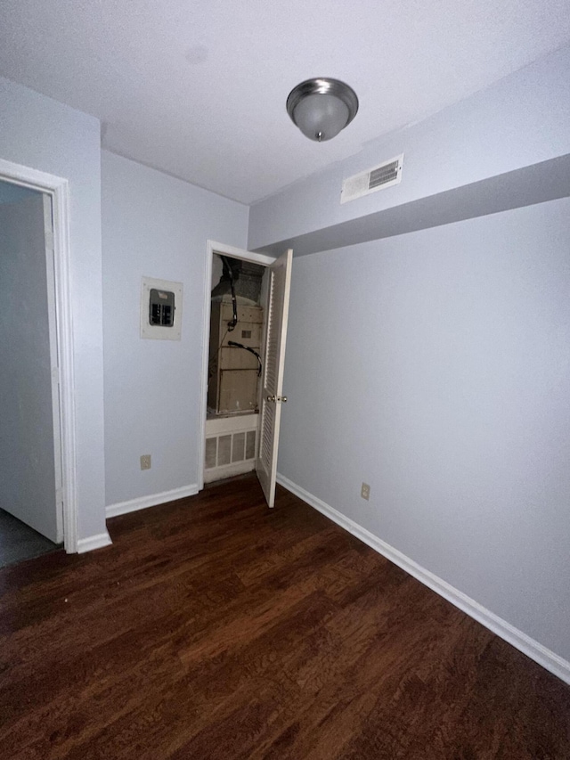 unfurnished room with dark wood-type flooring