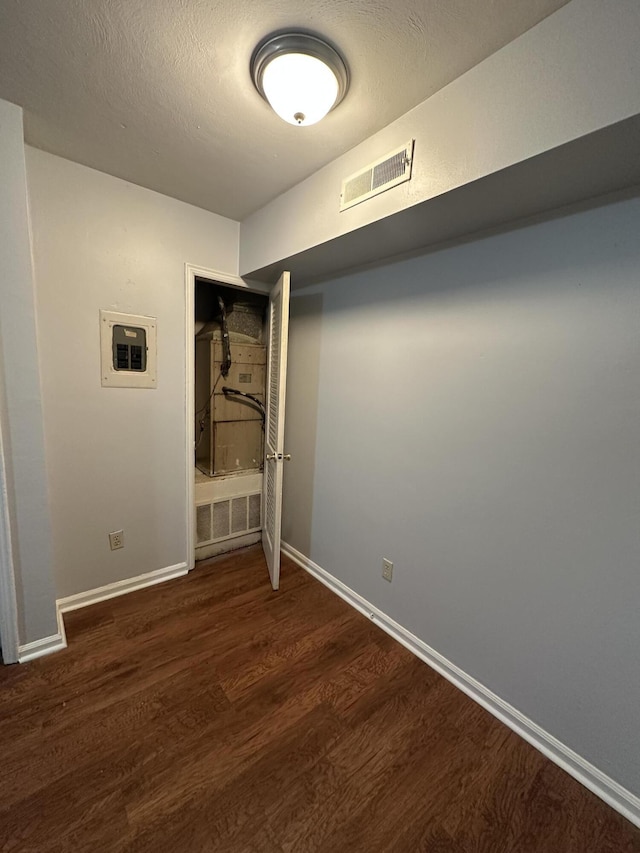 interior space featuring dark wood-type flooring and electric panel