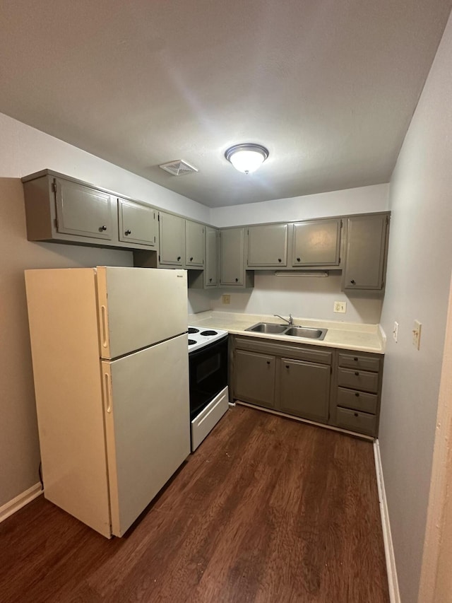 kitchen with dark wood-type flooring, sink, white appliances, and gray cabinets