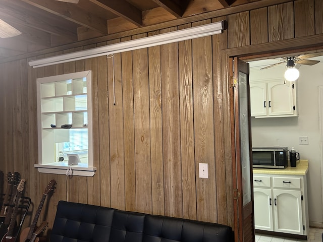 interior space with ceiling fan and wood walls