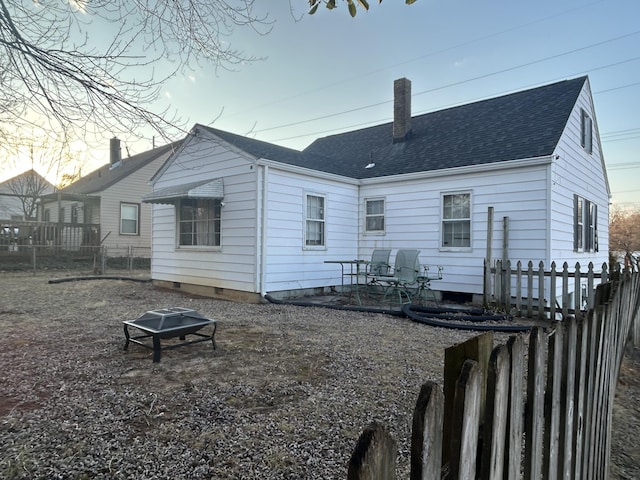 rear view of property featuring an outdoor fire pit