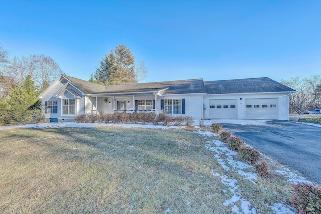 single story home with a front lawn, covered porch, and a garage