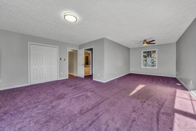 carpeted spare room featuring ceiling fan and a textured ceiling