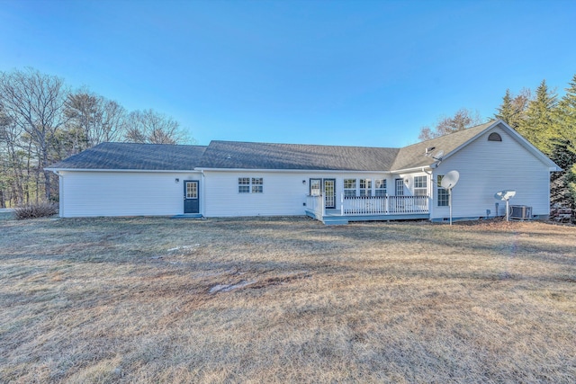 rear view of property featuring a wooden deck, central AC unit, and a yard