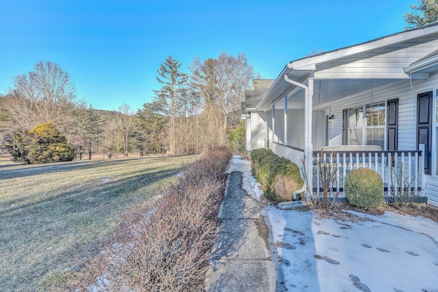 exterior space with covered porch and a lawn