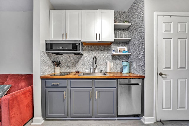 kitchen featuring tasteful backsplash, gray cabinets, sink, and white cabinets