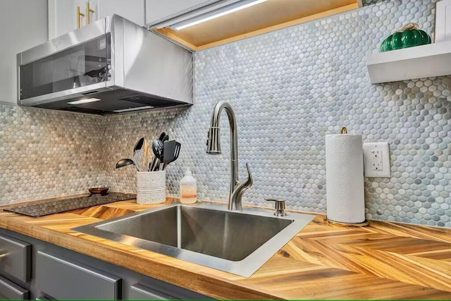 kitchen featuring wood counters, sink, decorative backsplash, and parquet floors