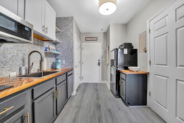 kitchen featuring gray cabinetry, white cabinetry, stainless steel appliances, and wooden counters