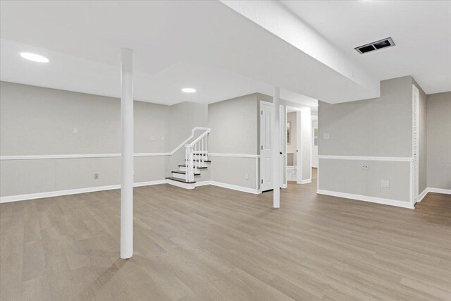 basement with light hardwood / wood-style flooring