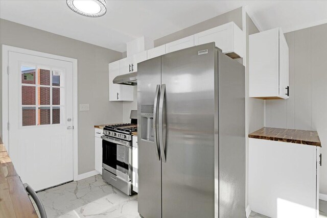 kitchen featuring stainless steel appliances, white cabinetry, and wood counters