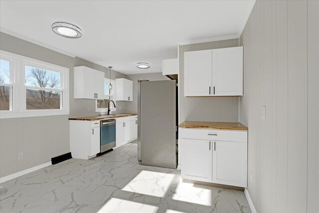 kitchen with stainless steel appliances, white cabinets, and butcher block counters