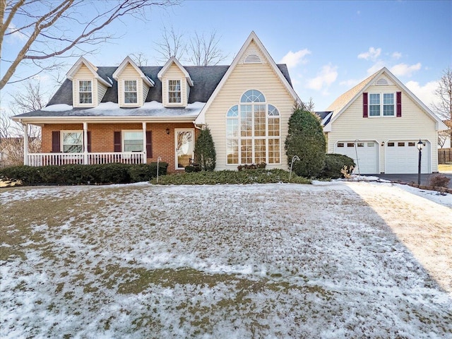 new england style home with covered porch and a garage