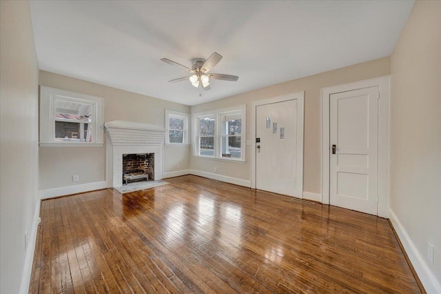 unfurnished living room with ceiling fan, hardwood / wood-style floors, and a fireplace