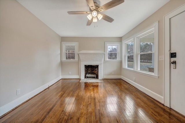 unfurnished living room with ceiling fan, a fireplace, and hardwood / wood-style flooring