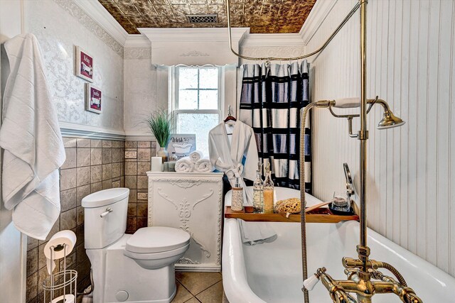 bathroom with toilet, tile walls, ornamental molding, a tub, and tile patterned flooring