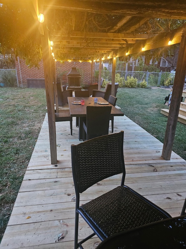 wooden deck with an outdoor fireplace and a yard