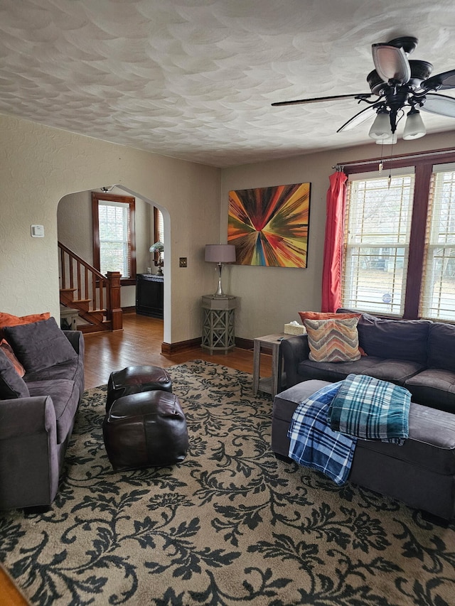 living room with ceiling fan, hardwood / wood-style flooring, and a textured ceiling