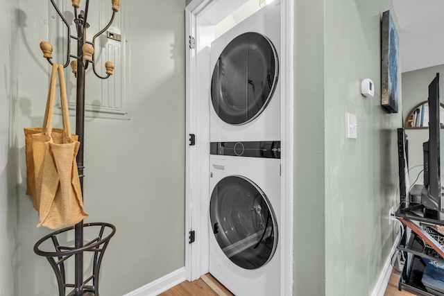 washroom featuring stacked washer and dryer and light wood-type flooring