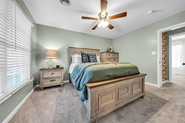 carpeted bedroom featuring ceiling fan and multiple windows