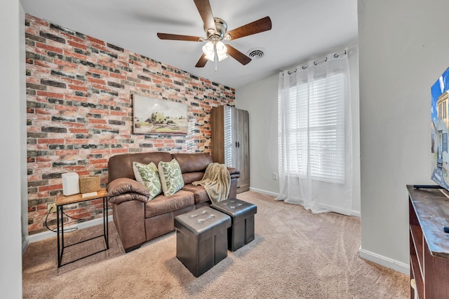 living room with ceiling fan, brick wall, and light carpet