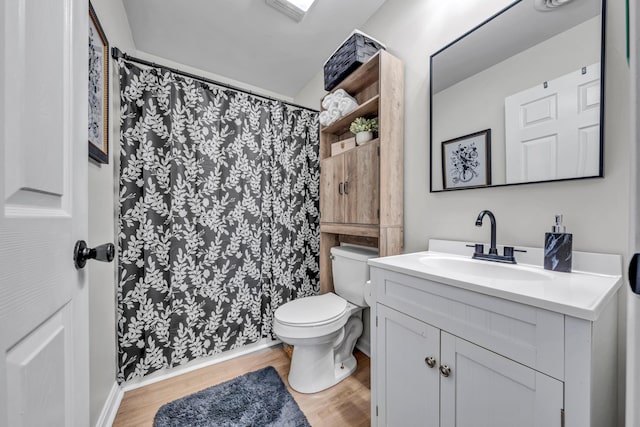 bathroom with toilet, vanity, and hardwood / wood-style flooring