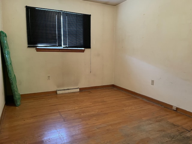 spare room with baseboard heating and hardwood / wood-style floors