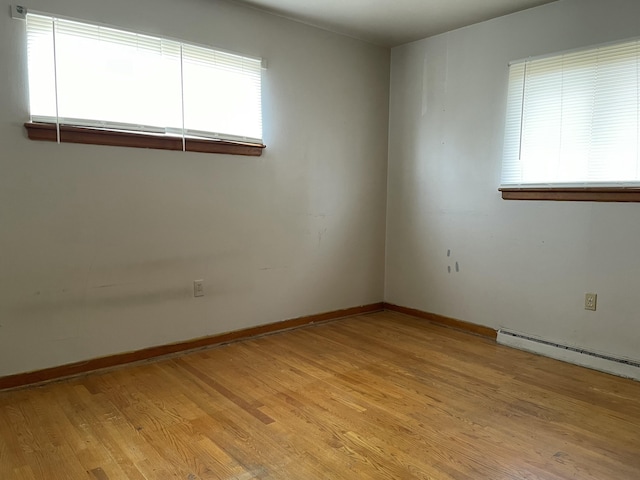 spare room with a baseboard radiator and light hardwood / wood-style floors