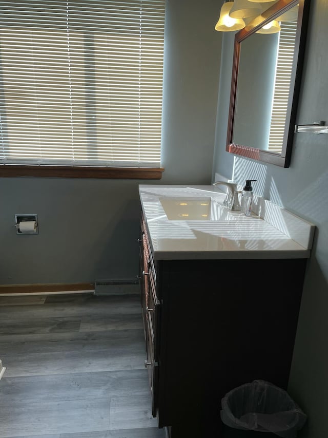 bathroom featuring a baseboard heating unit, hardwood / wood-style floors, and vanity