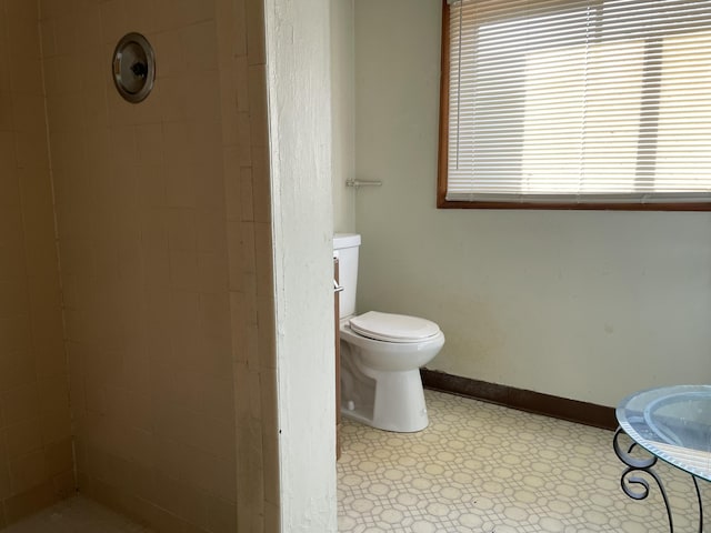 bathroom featuring toilet and a tile shower