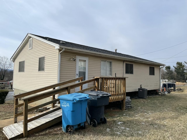 rear view of property with a wooden deck and cooling unit