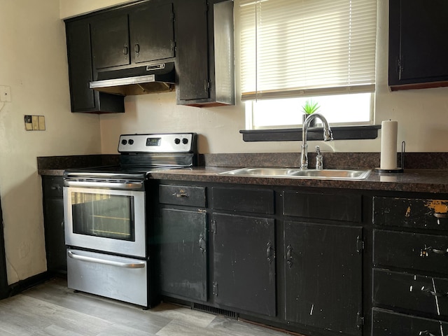 kitchen featuring sink, electric range, and light hardwood / wood-style flooring